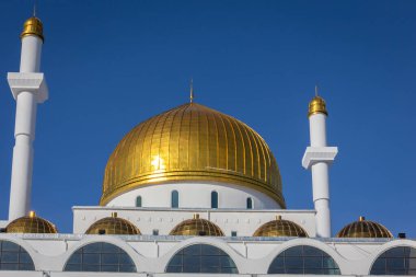 Astana, Kazakistan 'daki Nur Astana Camii (Abu Nasr Al-Farabi Meshiti) beyaz cepheli, altın kubbeli ve mavi gökyüzüne karşı minareler.