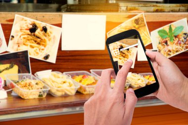 Adam arka planda Amerikan yemekleri siparişi veren akıllı telefon kullanıyor..
