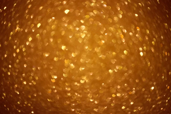 An abstract gold background with sparkle lights and bokeh. Useful as Christmas background or greeting card. Gold blurred light.