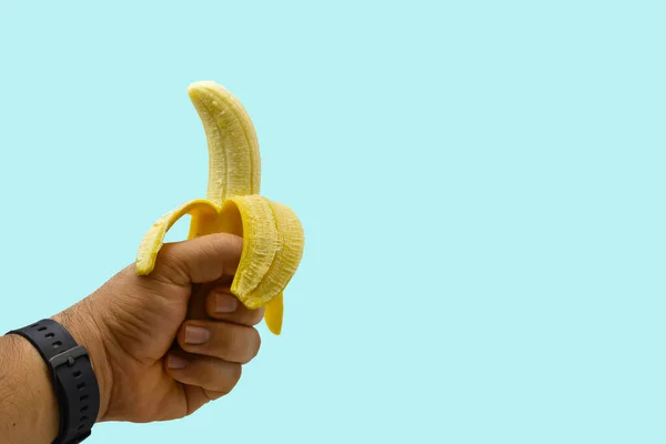Banan Lewej Ręce Niebieskim Tle — Zdjęcie stockowe