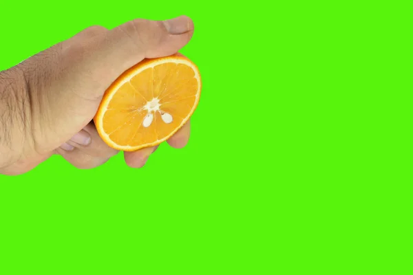 Mano Apretando Mitad Naranja Aislado Sobre Fondo Verde — Foto de Stock