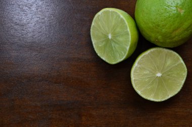 Ahşap masa arkasına konmuş limon dilimi. 