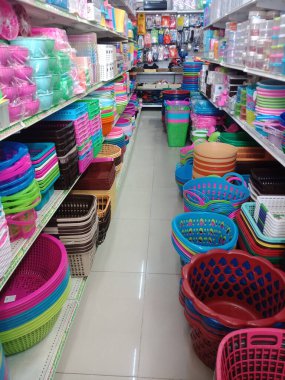 Süpermarketteki raflarda plastik sepetler, kaplar ve diğer plastik ürünler var.