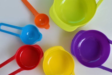 Renkli plastikten yapılmış bir kaşık seti. Plastik ölçüm kaşıkları, yakın çekim, mutfak ekipmanları.
