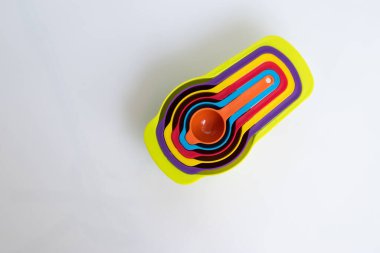 Renkli plastikten yapılmış bir kaşık seti. Plastik ölçüm kaşıkları, yakın çekim, mutfak ekipmanları.