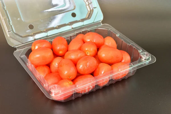 Tomates Envases Plástico Colocados Suelo Negro —  Fotos de Stock
