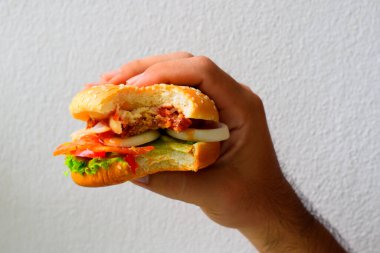 Hamburgerler sağ eliyle ısırılmış..