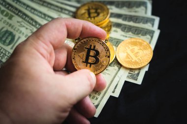bir hans bir altın sikke tut bitcoin doları bir arka plan üzerinde faturaları madeni paralar bitcoin vardır