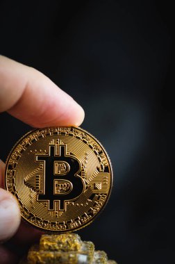 bir parmak bir altın sikke bitcoin piramidin tepesinde tutar