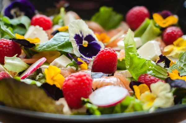 salad with raspberry fruit, flowers, cheese and salmon