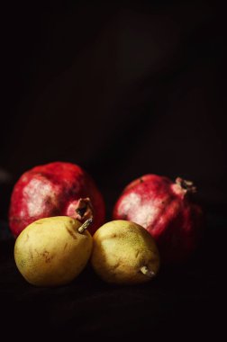 parlak, olgun pomogranate ve siyah arka plan üzerine armut