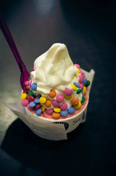 Yoghurt ijs bestroopt met kleurrijke snoepjes — Stockfoto