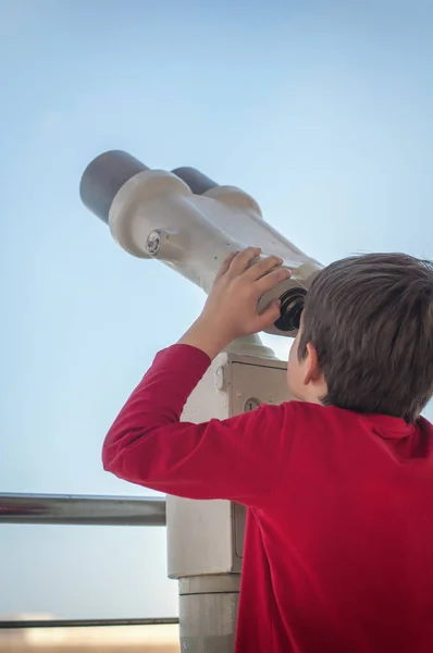 少年は観光望遠鏡を見ている — ストック写真