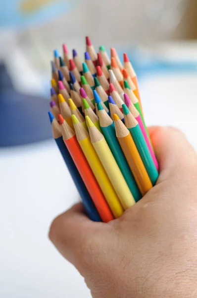 Skupina jasně barevných tužek v ruce — Stock fotografie