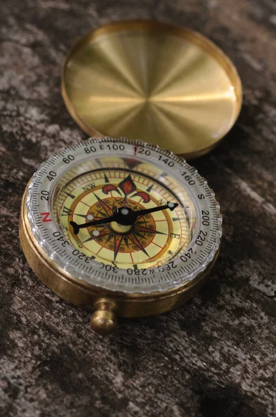 Golden vintage compass on wooden background with natural light — Stock Photo, Image