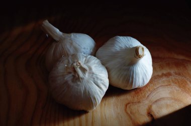 Tahtadaki sarımsak, karanlık ışıkta.