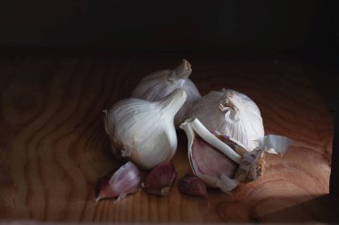Tahtadaki sarımsak, karanlık ışıkta.