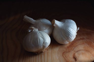 Tahtadaki sarımsak, karanlık ışıkta.