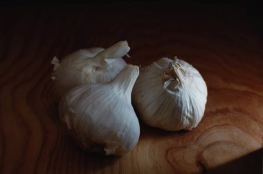 Tahtadaki sarımsak, karanlık ışıkta.