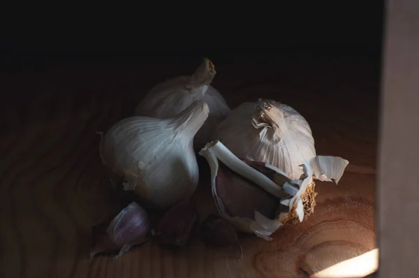 Three Garlic Heads Wooden Board Dark Lighting — Stock Photo, Image