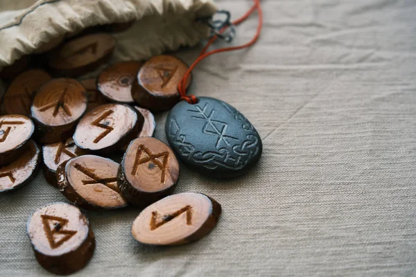 Runas de madeira em um saco de lona com um runescript de pedra — Fotografia de Stock
