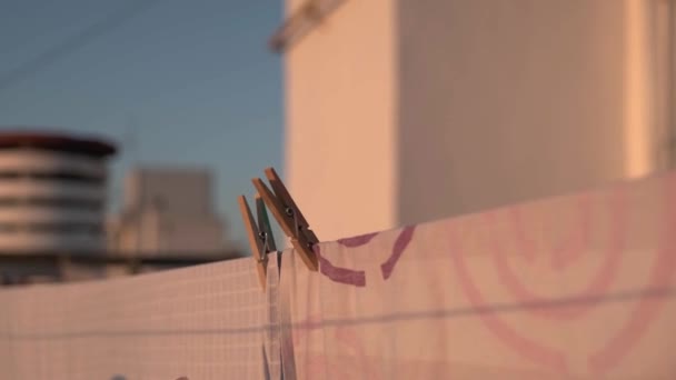 Дівчина прибирає одяг з мотузки — стокове відео