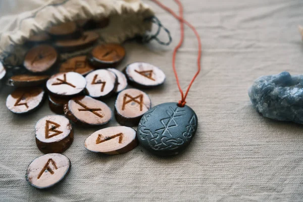 Runas de madera en una bolsa de lona con un runescript de piedra — Foto de Stock