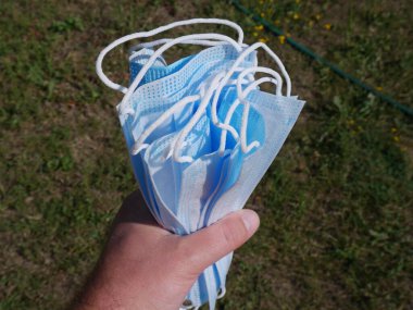 Elinde tıbbi maske paketi var. 