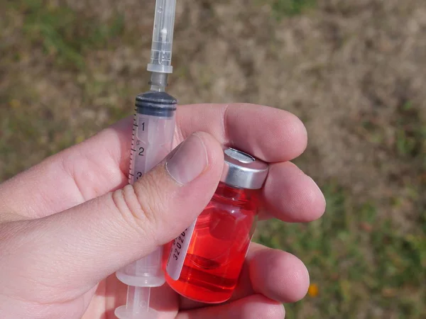 Frasco Medicamento Rojo Una Jeringa Mano —  Fotos de Stock