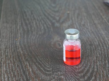 Kırmızı ilaç şişesi koyu bir arka planda