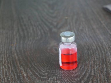 Kırmızı ilaç şişesi koyu bir arka planda