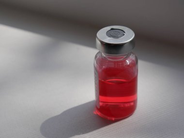 Beyaz arka planda kırmızı ilaç şişesi 