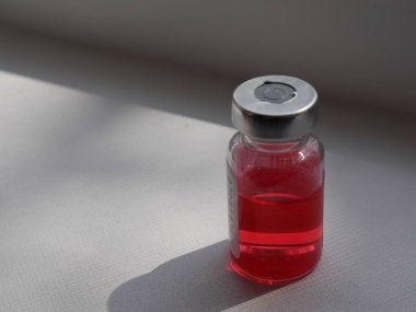 Beyaz arka planda kırmızı ilaç şişesi