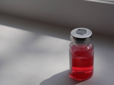 Beyaz arka planda kırmızı ilaç şişesi