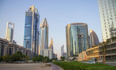 Dubai Finans Merkezi yolu. Resimde Jumeirah Emirates kuleleri, Ritz Carlton, Park kuleleri, DIFC gibi simgeler yer alıyor. Açık havada.
