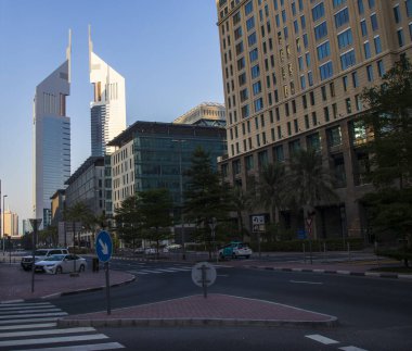 Dubai Finans Merkezi yolu. Resimde Jumeirah Emirates kuleleri, Ritz Carlton, DIFC gibi simgeler yer alıyor. Açık havada.