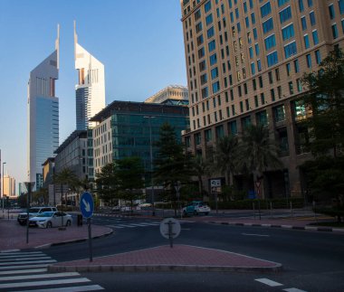 Dubai Finans Merkezi yolu. Resimde Jumeirah Emirates kuleleri, Ritz Carlton, DIFC gibi simgeler yer alıyor. Açık havada.
