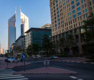 Dubai Finans Merkezi yolu. Resimde Jumeirah Emirates kuleleri, Ritz Carlton, DIFC gibi simgeler yer alıyor. Açık havada.