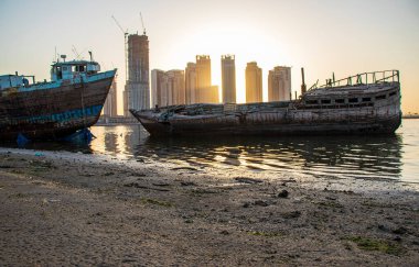 Dubai 'nin Jadaf bölgesinde gün doğumu, Dubai Creek Limanı inşaatı kısmen tamamlandı. Eski terk edilmiş gemiler olay yerinde görülebilir. Açık havada.