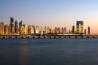 Jumeirah Sahili manzarası ve mavi su geçirmez gün batımı. Palm Jumeirah 'dan yapılmış, insan yapımı ada. Dubai, BAE. Açık havada..