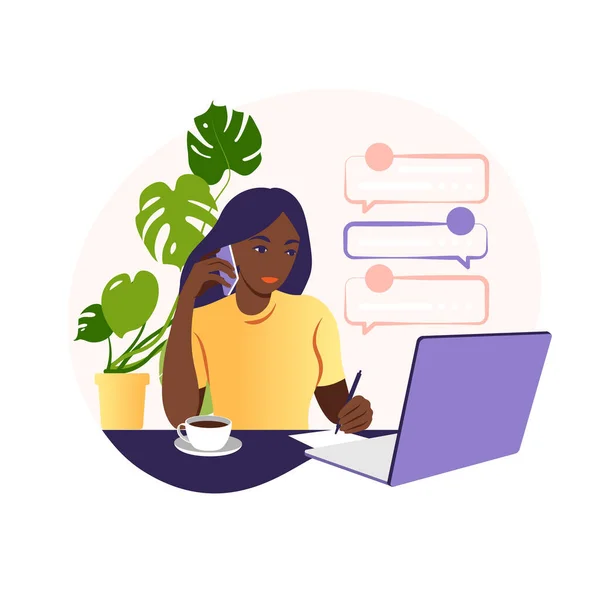 African woman works on a laptop computer and talks on the phone sitting at a table at home with a Cup of coffee and papers. Vector illustration. Flat. — Stock Vector