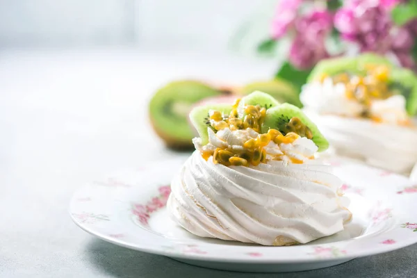 Homemade cake Pavlova with whipped cream, fresh kiwi and passion fruit. Selective focus