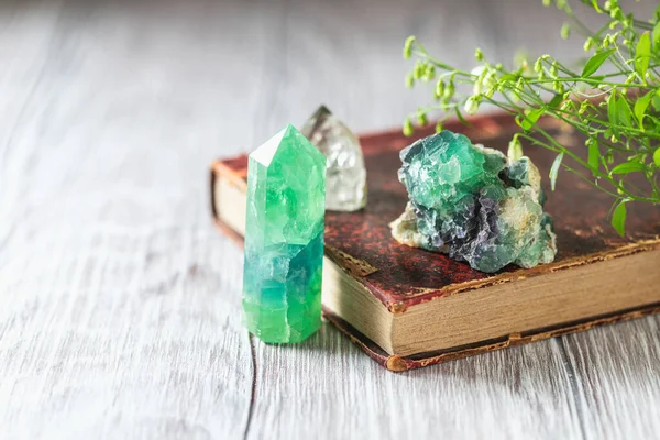 Old book and mineral stones crystals. Crystal Ritual, Healing Crystals. Natural gemstones. Gemstones are full of healing energy and good vibes. Selective focus, copy space.