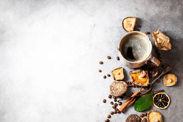 Mushroom coffee, a ceramic cup, mushrooms and coffee beans on stone concrete background. New Superfood Trend. Copy space, top view, copy space