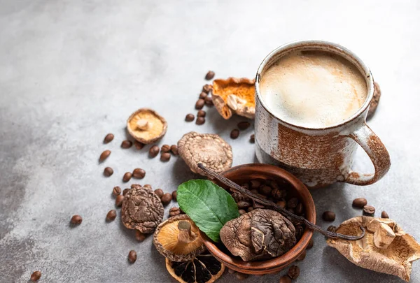 Mushroom coffee, a ceramic cup, mushrooms and coffee beans on stone concrete background. New Superfood Trend. Copy space, top view, copy space