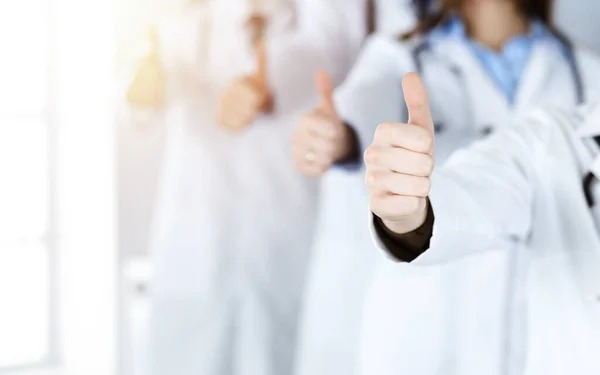 Gruppe moderner Ärzte, die als Team mit erhobenem Daumen im sonnigen Krankenhaus stehen. Medizinische Hilfe, Versicherung im Gesundheitswesen, beste Krankheitsbehandlung und medizinisches Konzept — Stockfoto