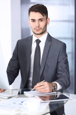 Modern ofiste bilgisayarla çalışan bir iş adamı. Arap erkek girişimcinin ya da iş yerindeki müdürün vesikalığı. İş konsepti