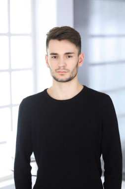 Modern ofiste sakallı adamın vesikalığı. İş adamı ya da öğrenci, dik durup gülümsüyor. Yaşam tarzı kavramı