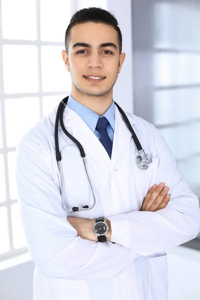 Homem médico árabe de pé com braços cruzados em consultório médico ou clínica. Conceito de medicina e saúde — Fotografia de Stock