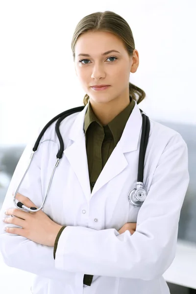 Doctora de pie recta y mirando a la cámara. Servicio médico perfecto en la clínica. Futuro feliz en medicina y salud — Foto de Stock